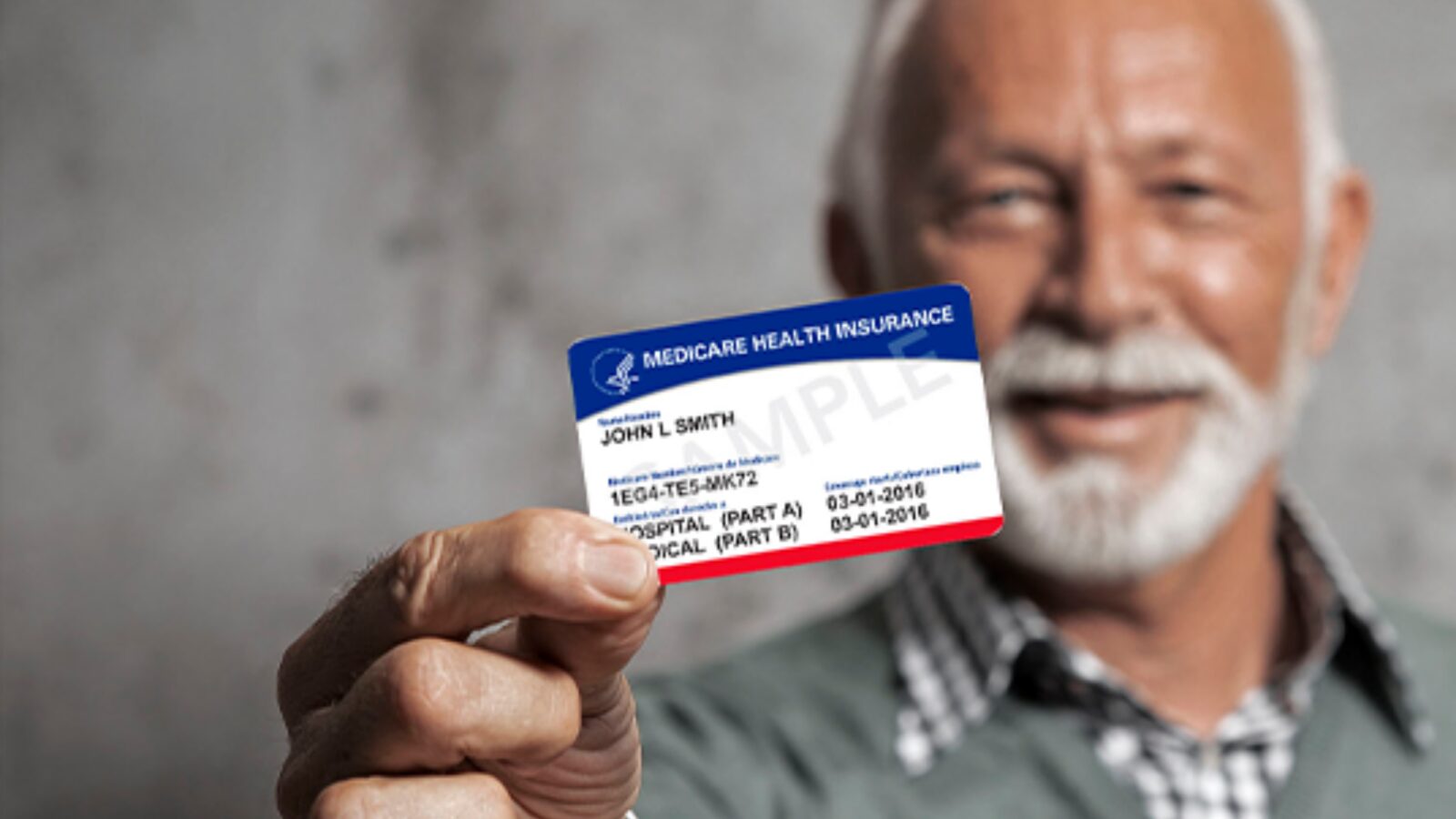 An older man with a white beard holds up a sample Medicare card showing Part A and Part B.